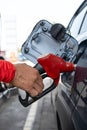 Man hand refuel to car, gasoline fuel nozzle in vehicle at petrol station. Refueling gun at the refuel station Royalty Free Stock Photo