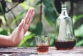 Man hand rejecting glass with alcoholic beverage on table outdoors background - refuses to drink a alcohol whiskey Royalty Free Stock Photo