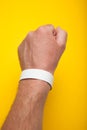 Man hand with round wristband for an event bracelet on the arm, mockup