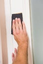 Man hand sanding the door before refinishing