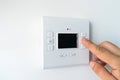 Man hand setting the room temperature on a modern programmable thermostat water heater boiler. Smart home. Royalty Free Stock Photo