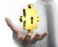 Man hand showing golden puzzle piece with keyhole Royalty Free Stock Photo