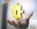 Man hand showing golden puzzle piece with keyhole Royalty Free Stock Photo