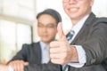 Man hand showing thumbs up on the foreground. Businessman showing OK sign with his thumb up. Selective focus on hand Royalty Free Stock Photo