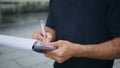 Man hand signing agreement at street close up. Businessman putting signature Royalty Free Stock Photo