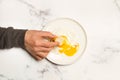 Man hand with a slice of bread and a broken fried egg on a white plate Royalty Free Stock Photo