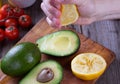 Man hand squeezing lemon on avocado Royalty Free Stock Photo