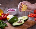 Man hand squeezing lemon on avocado Royalty Free Stock Photo