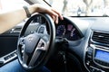 Man hand on Steering wheel in the cabin of a Korean Hyundai car. Selection and purchase of used car