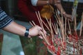 Man hand sticks burning incense in incense pot in Buddhist Temple. Buddhism, Asian traditional religious ceremony, Rituals, Making Royalty Free Stock Photo