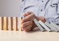 Man hand stopping domino effect. Insurance, risk management concept. Business recovery. Financial crisis, failure Royalty Free Stock Photo