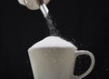 Man hand with sugar bowl pouring a crazy lot in full coffee cup in addiction concept Royalty Free Stock Photo