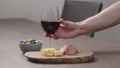 man hand take glass of red wine with appetizers on table Royalty Free Stock Photo