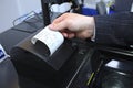 Man hand taking the receipt from printer of the cash recycler working