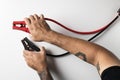 Man hand with tattoo holding jumper cable isolated on white background Royalty Free Stock Photo