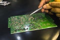 The man hand of the technician assembling manualy electronic components and microcircuits on printing circuit board with