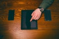 Man hand touch on a screen of mobile phone on a wooden table. Business situation. Royalty Free Stock Photo