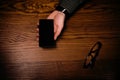 Man hand touch on a screen of mobile phone on a wooden table. Business situation. Royalty Free Stock Photo