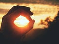 Man hand touch Sun. Fingers circle. Misty daybreak in a beautiful hilly landscape . Royalty Free Stock Photo