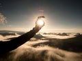 Man hand touch Sun. Misty daybreak in a beautiful hills. Royalty Free Stock Photo