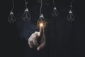 Man hand touching to hanging glowing drawing light bulb with orange rays , creative thinking idea and innovation concept Royalty Free Stock Photo