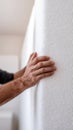 Man hand touching white soundproofing insulation material on wall. Worker preparing acoustic foam panel for installation. Home Royalty Free Stock Photo