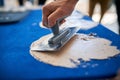 Man hand with trowel plastering a blue surface Royalty Free Stock Photo