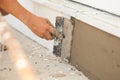 Man hand with trowel plastering a foundation of house. Royalty Free Stock Photo