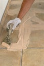 Man hand with trowel plastering a tiles, laying tiles.Construction concept Royalty Free Stock Photo