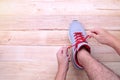 Man hand tying laces of running shoes before training on woode Royalty Free Stock Photo