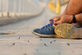 Man hand tying sport shoe laces in casual clothes after workout..Young fitness man running outside city. People fitness, exercise. Royalty Free Stock Photo