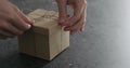 Man hand untie brown paper gift box on terrazzo countertop