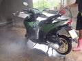 Man hand used red injection machine and wash green Motorbike