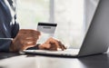 Man hand using laptop computer and holding credit card. Young businessman or entrepreneur working at office. Royalty Free Stock Photo