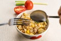 Man hand using metal spoon and fork scoop delicious thai style homemade pork and egg fried rice