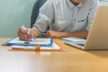 Man hand using pen to check financial number on document