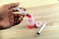 Man hand using syringe to draw sucking red medicine