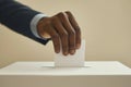 Man hand wearing black suit putting ballot into voting box. Politics, democracy, freedom, elections concept Royalty Free Stock Photo