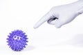 A man hand in a white medical glove scares and threatens by pointing finger purple virus ball on a white background