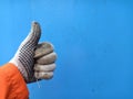 Man hand in work glove thumbs up isolated on blue background Royalty Free Stock Photo