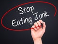 Man Hand writing Stop Eating Junk with black marker on visual sc Royalty Free Stock Photo