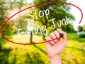 Man Hand writing Stop Eating Junk with black marker on visual sc Royalty Free Stock Photo