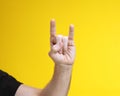 Man hand on yellow background showing two fingers meaning cool. Royalty Free Stock Photo