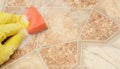Man hand in yellow glove with red sponge in washing solution on kitchen floor.Washing floors by the washing solution Royalty Free Stock Photo