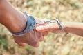 man handcuffed outdoors in the park