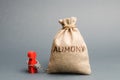 The man is handcuffed to a money bag with the word alimony. The concept of child support. Payments after a divorce. Financial