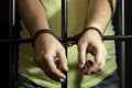 A man in handcuffs in a cell behind bars. Concept: a prisoner in a courtroom, a court sentence to a convicted person, a prison ter Royalty Free Stock Photo