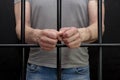 A man in handcuffs in a cell behind bars. Concept: a prisoner in a courtroom, a court sentence to a convicted person, a prison ter Royalty Free Stock Photo