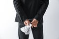 Man in handcuffs holding bribe money on background, closeup Royalty Free Stock Photo