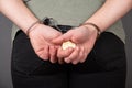 Man in handcuffs holding a gold bitcoin coin